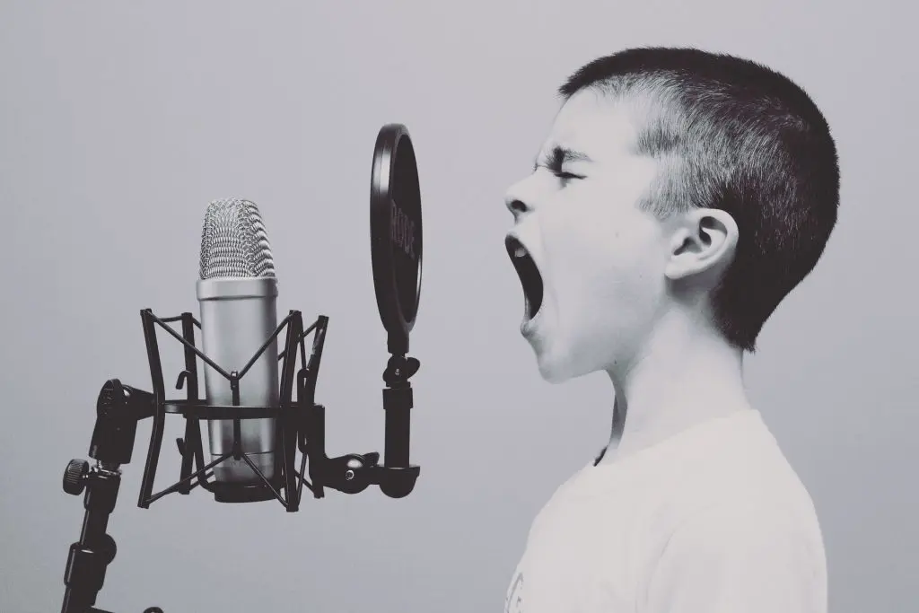 Child singing into an old-style microphone